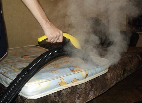 La photo montre un exemple de traitement d'un matelas à la vapeur chaude afin de détruire les punaises de lit et leurs œufs.